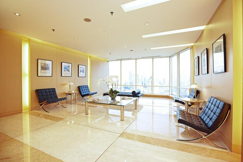 Spacious reception lounge at Wisma GKBI featuring designer chairs, marble floors, and panoramic city views.