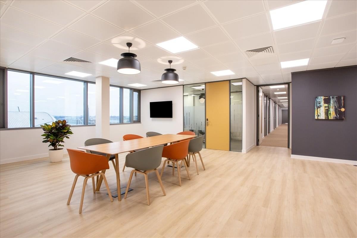 Spacious communal area at Wisma SSK featuring a long wooden table and modern light fixtures.