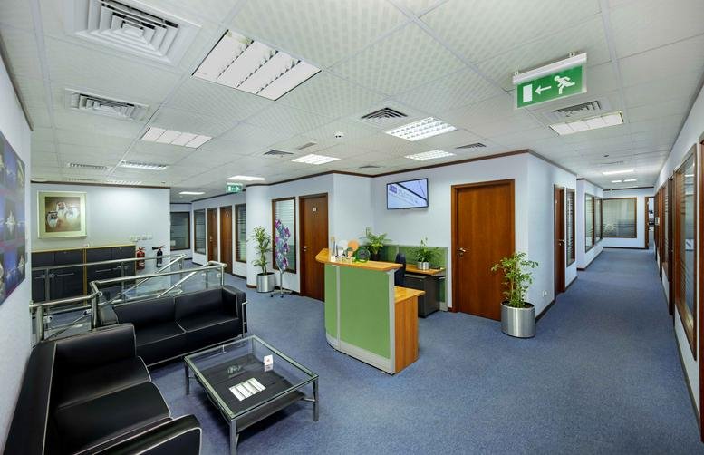 Spacious reception area of Al Jazira Sports & Cultural Club, Muroor Road, Abu Dhabi, UAE with green front desk.