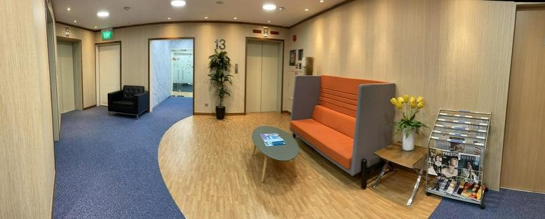 Spacious reception lobby at 07-01 The Octagon, 105 Cecil Street with wood flooring and orange lounge seating.