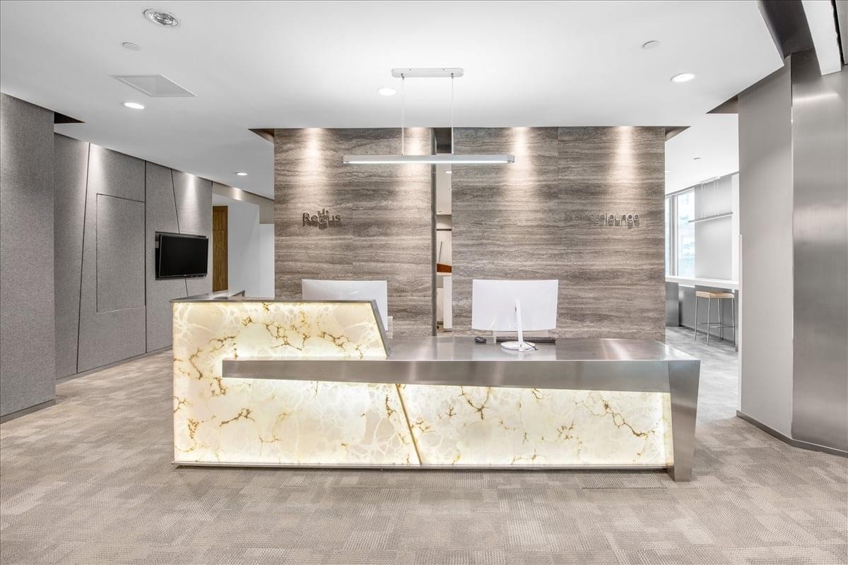 Grand reception desk with an illuminated stone facade at China Life Tower.