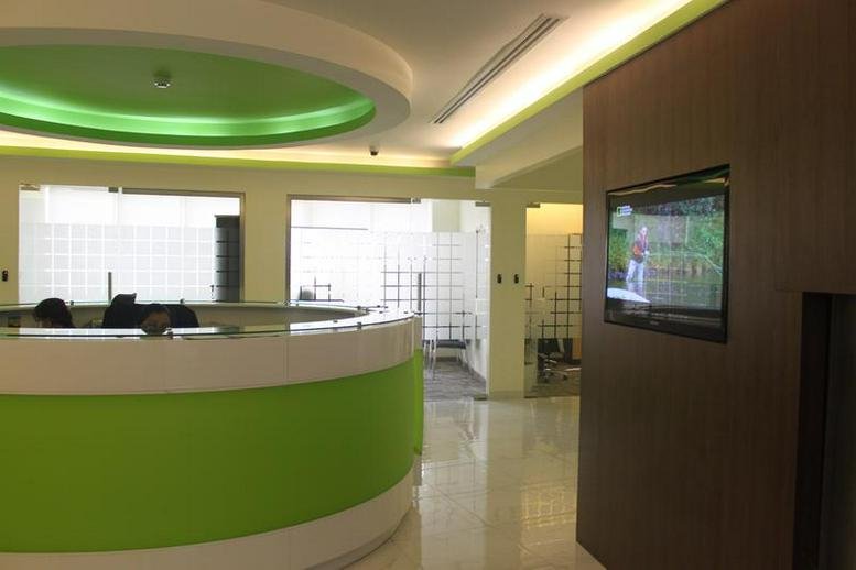 Modern reception desk with a bright green feature wall at Dusseldorf Business Point, Al Barsha 1.