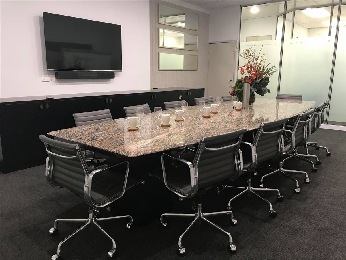 Large boardroom with a marble-topped table and wall-mounted television at Suite 5, 531 Hay Street.