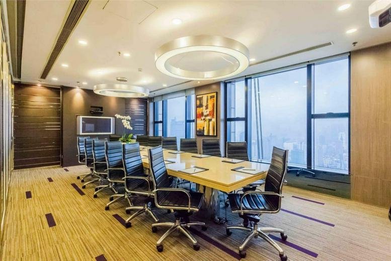 Spacious boardroom with glass walls and views of the city skyline.
