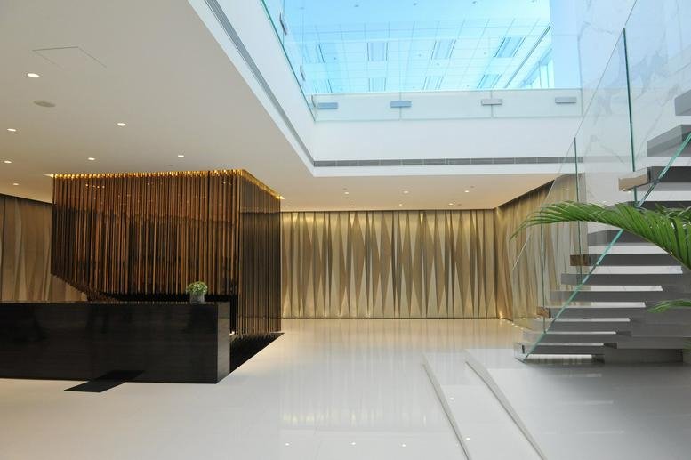 Modern minimalist reception area with a black front desk and a unique hanging wood feature.