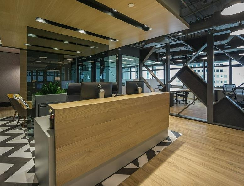 Modern reception area at Singapore Land Tower, 50 Raffles Place with wood paneling and chevron flooring.