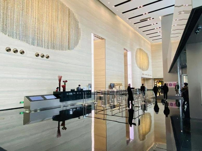 Spacious lobby area with reflective flooring and decorative wall features.