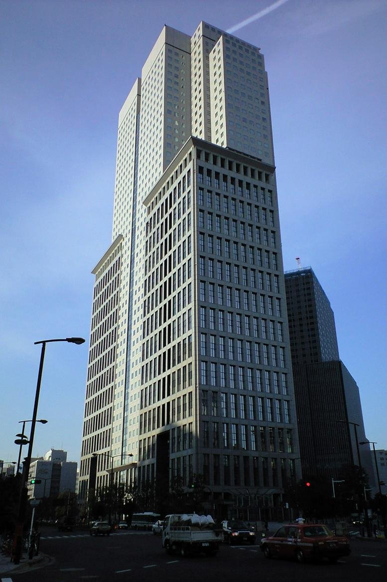 Exterior view of the towering glass and stone facade of Sanno Park Tower against a clear blue sky.