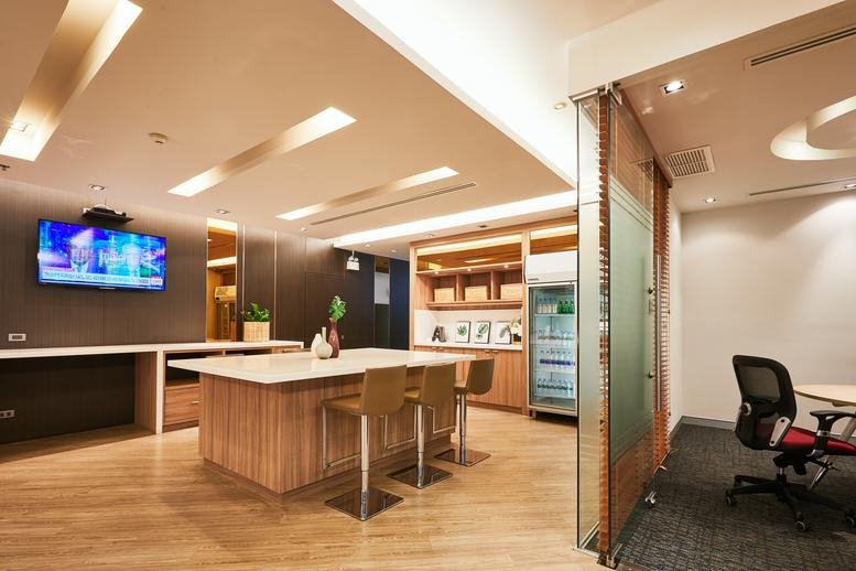 Modern interior of the Sathorn Thani Building 1 showing a bright communal island and glass-walled office.