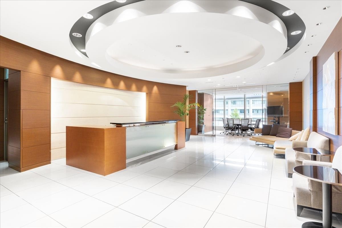 Bright reception area with a wood-fronted desk and a circular ceiling feature.
