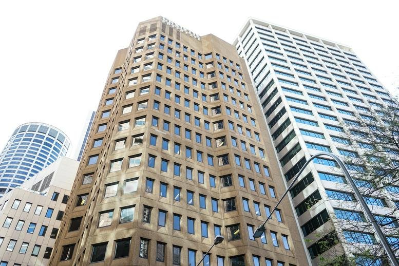 Exterior view of the tan masonry and glass skyscraper at 3 Spring Street, Sydney, Australia.