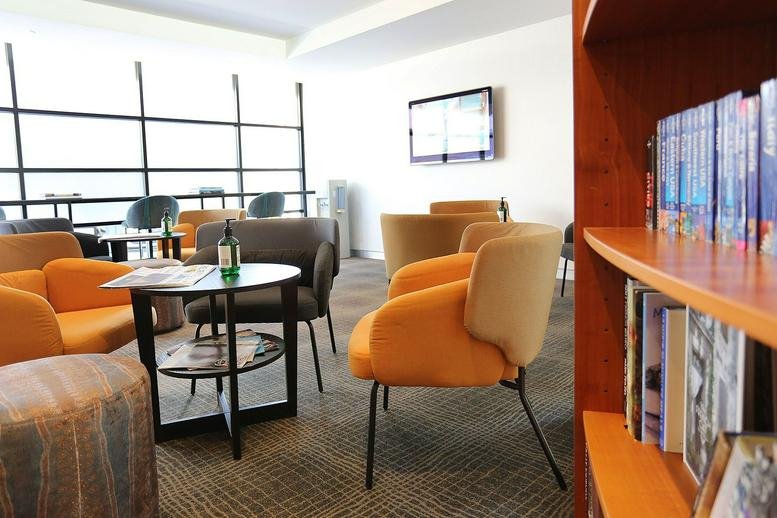 Contemporary lounge area at 45 Ventnor Avenue, West Perth, Australia with orange armchairs and a library shelf.