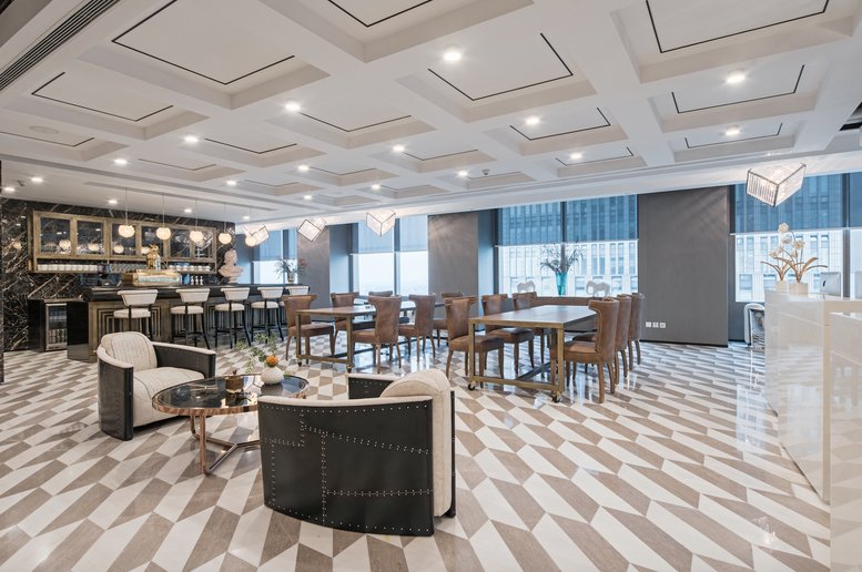Elegant reception lounge featuring designer armchairs and coffered ceilings.