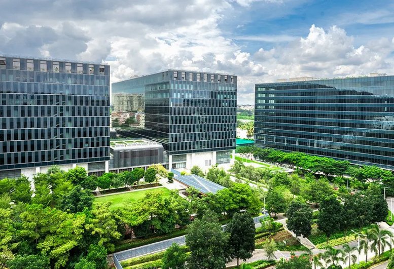 Aerial view of the modern glass buildings at Redbrick Offices, Helios Business Park surrounded by lush green landscaping.