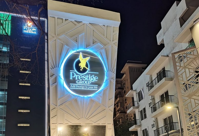 Exterior view of Prestige Summit building at night with illuminated signage.