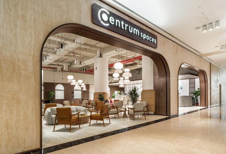 Entrance to the Centrum Spaces office at Reem Mall featuring warm wooden archways and a soft lounge area.