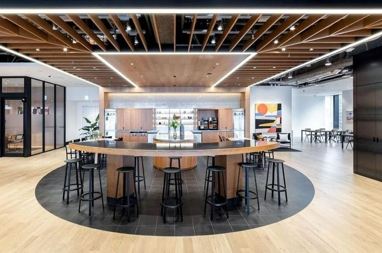 Spacious communal lounge with a curved bar and wooden ceiling at Tokyo Port City Takeshiba Office Tower.