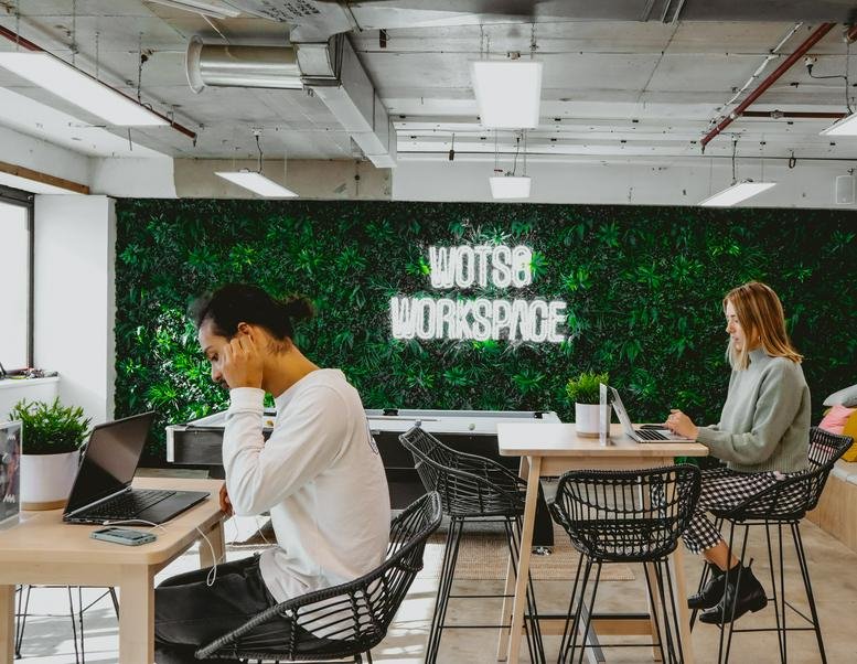 Spacious communal coworking lounge at 7 Neptune Street, Woden, Canberra featuring a green plant wall.