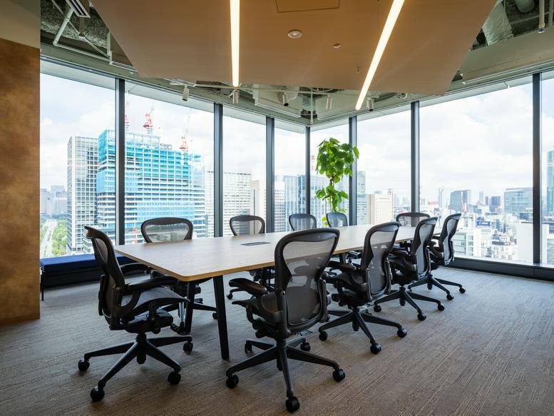 Professional boardroom at Toranomon Hills Business Tower with city views and ergonomic mesh chairs.