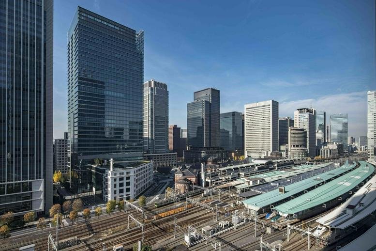 Exterior view of the glass-facade Gran Tokyo South Tower overlooking the city rail lines.