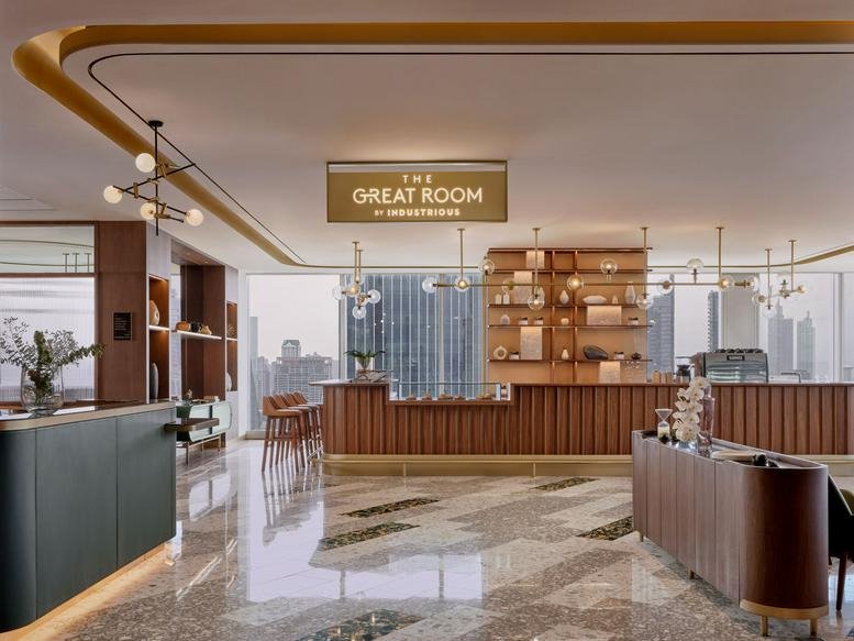 Grand reception lobby with a marble floor and a branded wood-paneled counter at Park Silom Tower.
