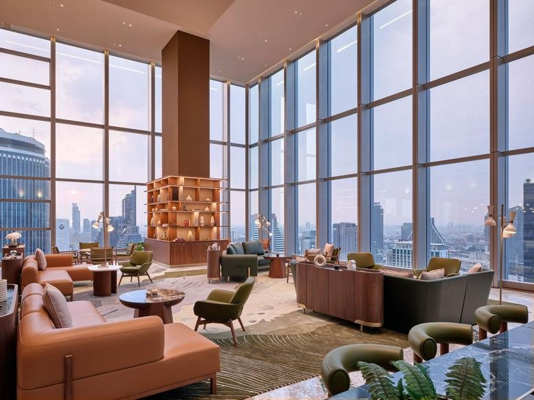 Expansive communal lounge with diverse seating options and high ceilings overlooking the city.