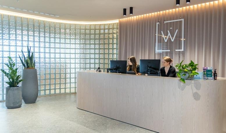 Modern reception desk at 1 Janefield Drive, Bundoora, Level 2/5 with a glass block wall and potted plants.