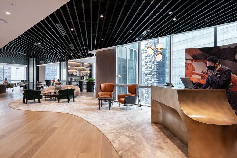 Reception area at 1 Marina Boulevard with a gold-toned curved desk and modern lounge seating.