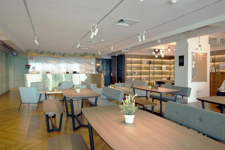 Spacious communal lounge at 1 North Bridge Road, High Street Centre No. 08-08 with warm lighting and wooden flooring.