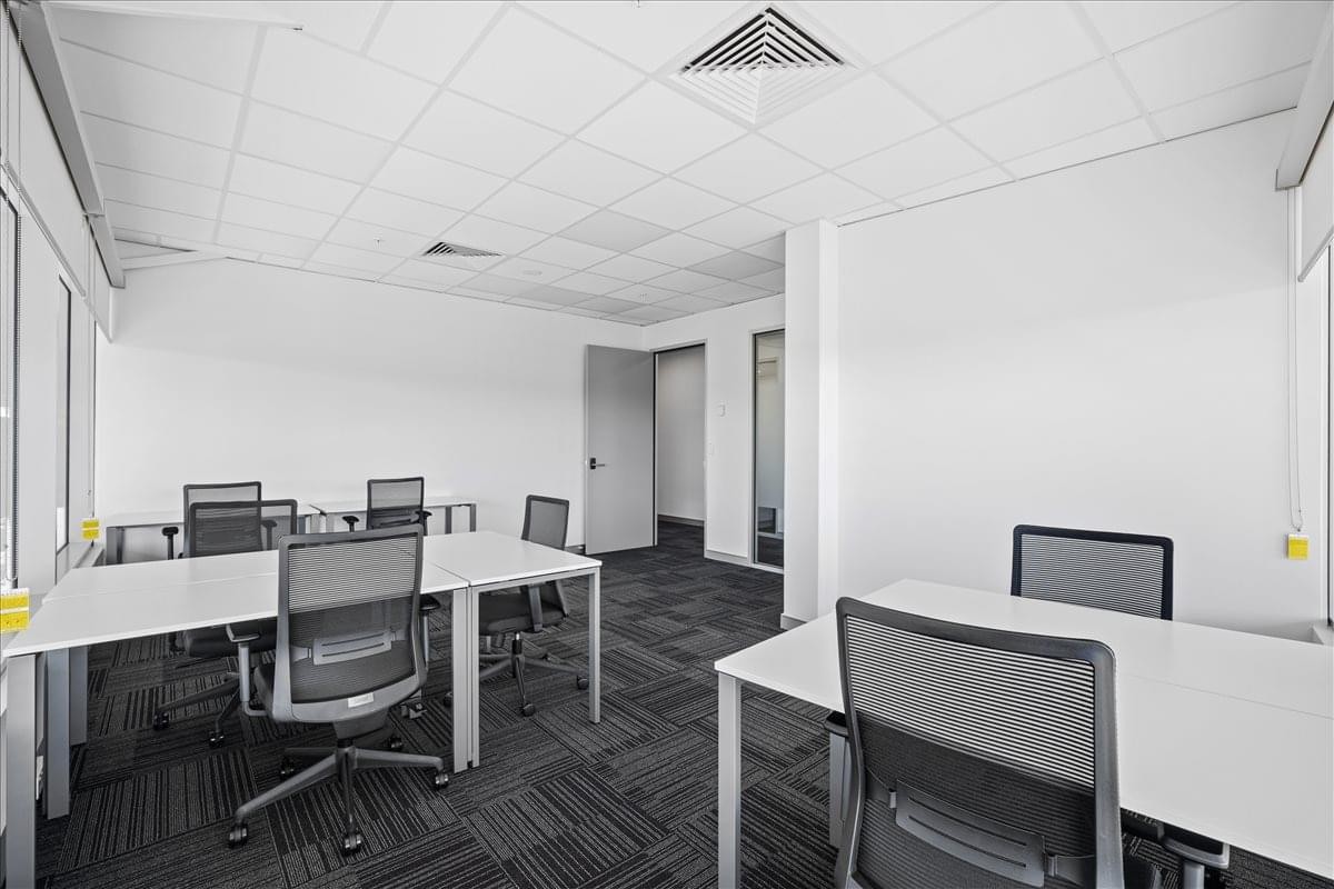 Spacious open-plan workspace at 1 Palmerston Circuit with white desks and ergonomic chairs.