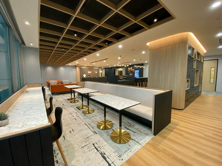 Spacious communal lounge at Smartworks Great Eastern Centre featuring marble tables and booth seating.