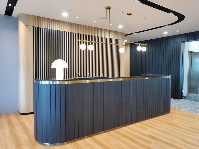 Modern reception area at 1, Pickering Street, Singapore featuring a blue slatted desk and globe lighting.