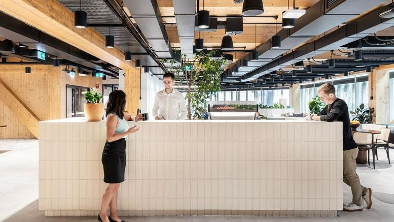 Spacious, modern lobby at 1 Sussex Street featuring a tiled reception desk and warm timber accents.