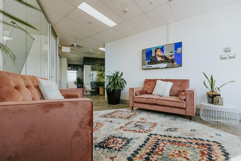 Bright reception lounge with velvet sofas and patterned rug at 1 Tudor Street, Newcastle West.