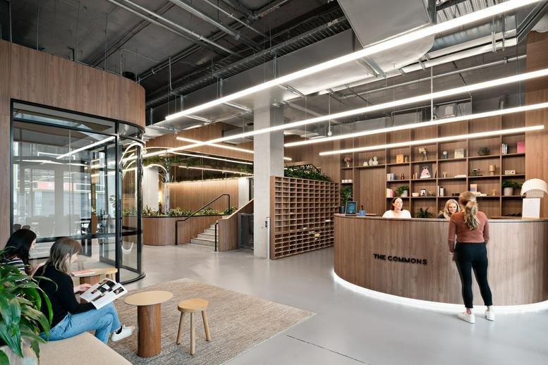 Reception and lobby at 10-20 Gwynne Street with curved wood desk and industrial ceilings.