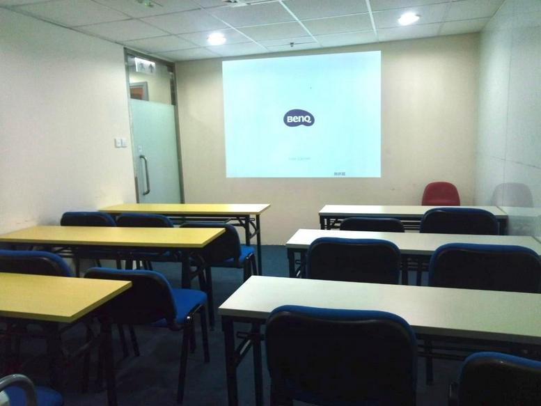 Classroom-style training room at China United Plaza with projector screen and rows of tables.