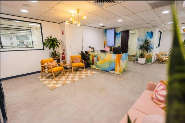 Vibrant reception area at 11-13 Lord Street, Level 1, Unit 7, featuring a colourful desk and yellow armchairs.