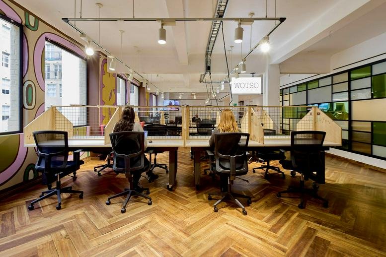 Quiet workstations arranged in a row with ergonomic black mesh office chairs.
