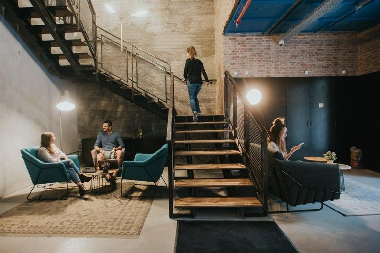 Spacious communal lounge at 111 Arlozorov Street, 2nd and 3rd floors, with stairs and modern seating.