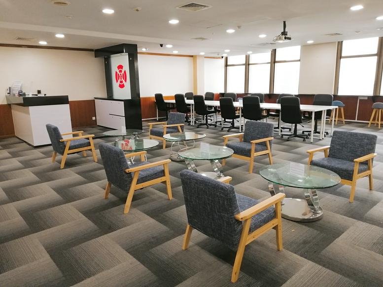 Spacious communal lounge at 111 North Bridge Road with stylish patterned carpet and glass coffee tables.