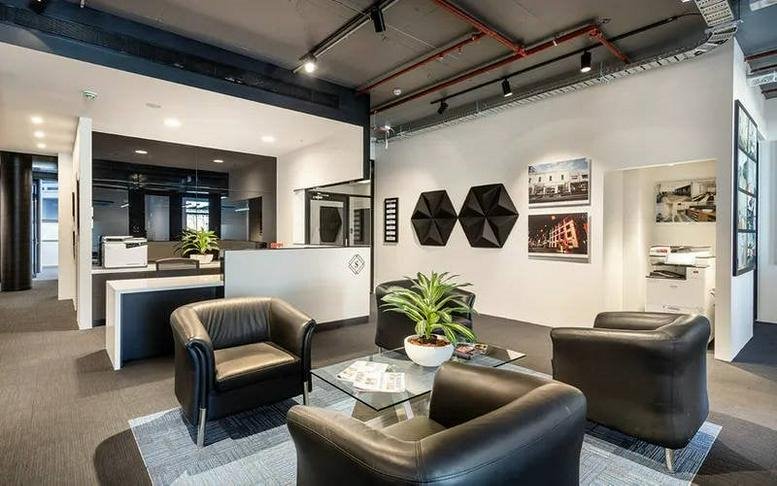 Modern lobby area at Level 1, 115 Bridge Road, Richmond featuring leather seating and a minimalist front desk.