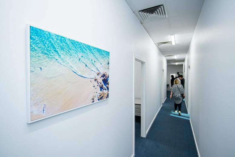 Hallway at 119 Murray street, Gawler featuring vibrant beach artwork and blue carpet.