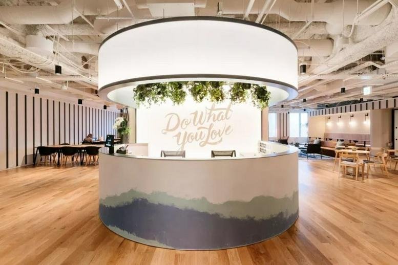 Round reception desk at Nanjing IFC Phase I with a scenic mural and overhead lighting.