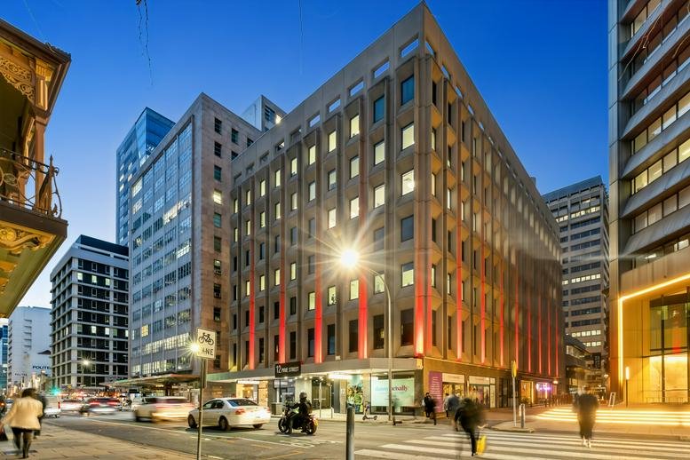 Wide-angle street view of the multi-story heritage and modern building at sunset.