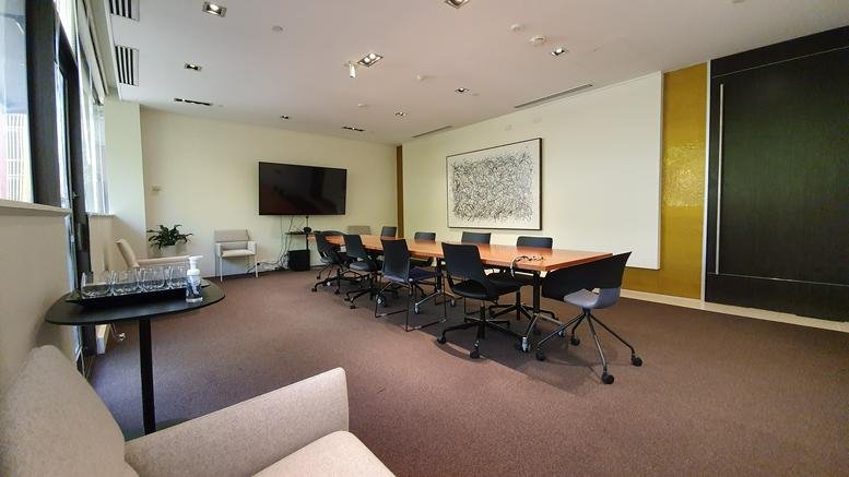Spacious boardroom at 123 Camberwell Road with a large table, black chairs, and a flat-screen TV.