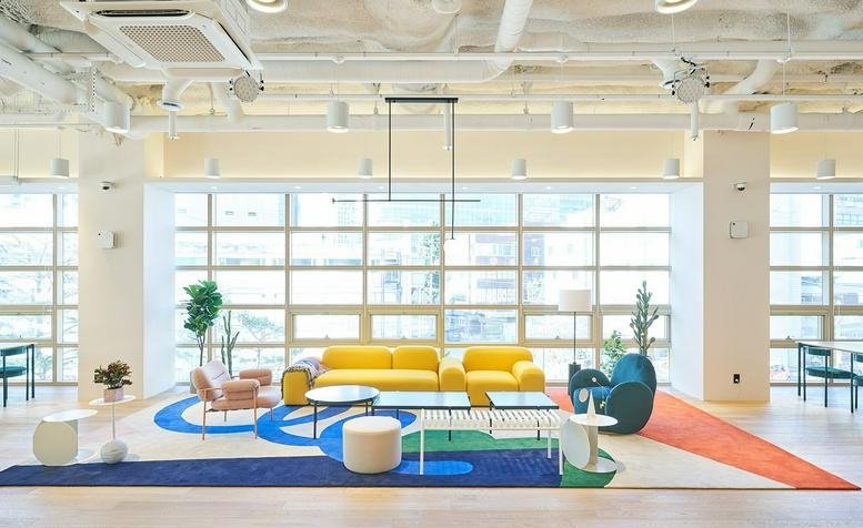 Spacious sunlit lounge at 125, Wangsimni-ro, Seoul Forest featuring yellow sofas and colorful geometric rugs.