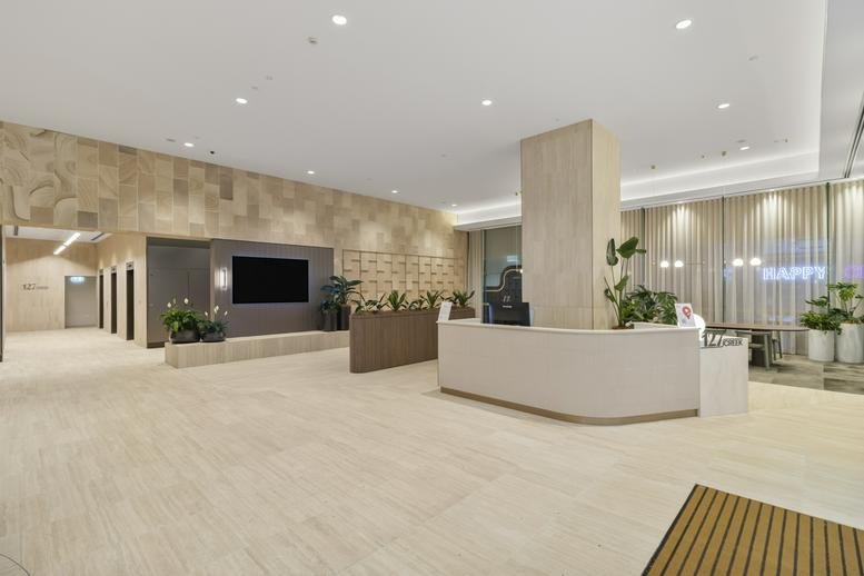 Bright lobby with a white curved reception desk and warm wood-panelled walls.
