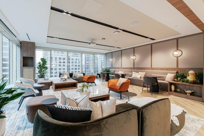 Spacious sunlit lounge with modern armchairs and city views at 135 King Street, Level 19.