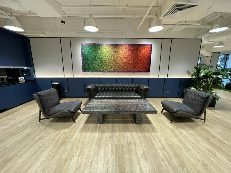 Breakout space with a plush leather sofa, coffee table, and colourful mural.
