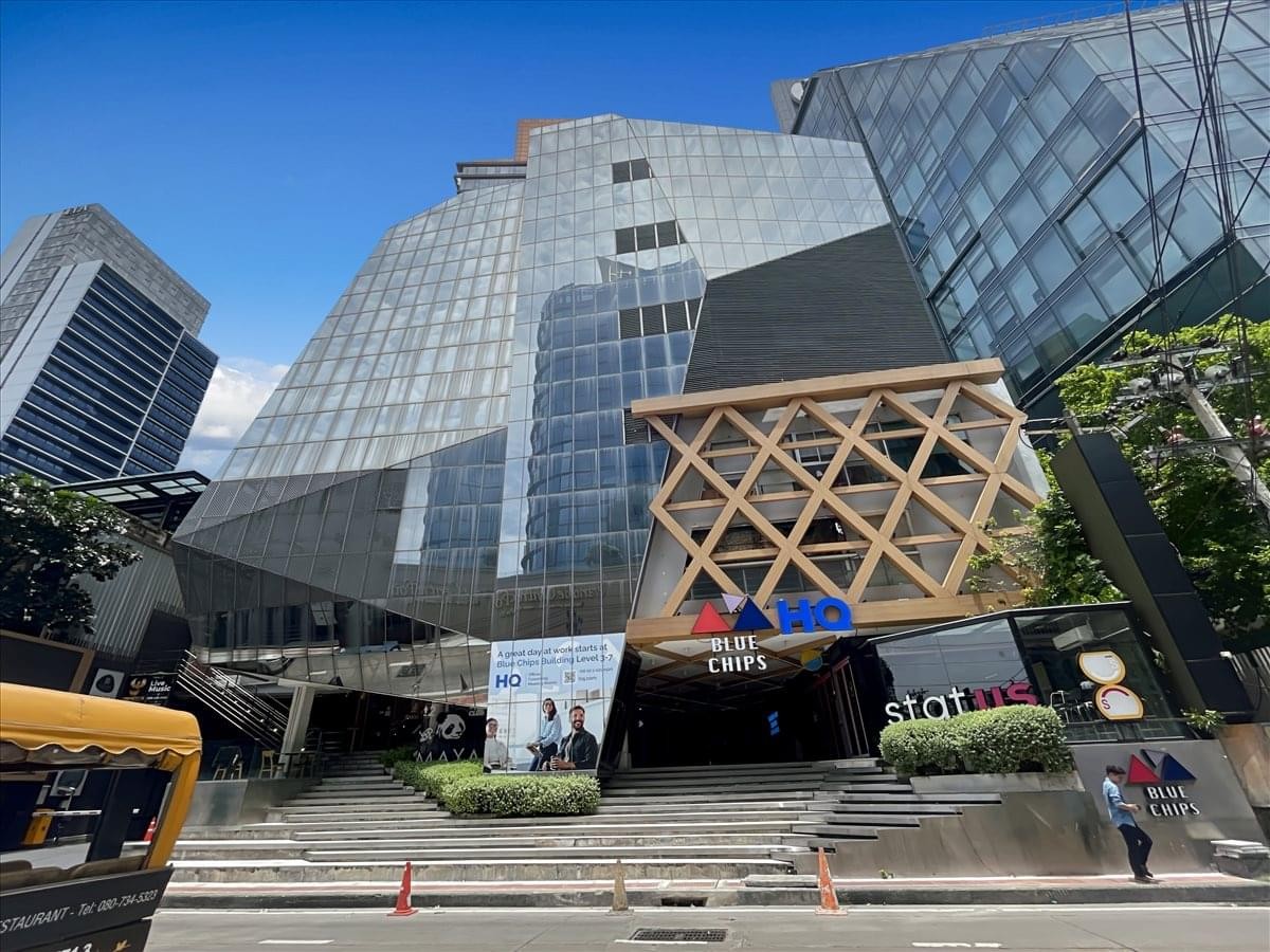 Modern glass facade exterior of the Blue Chips Building with a distinctive lattice wooden entrance.